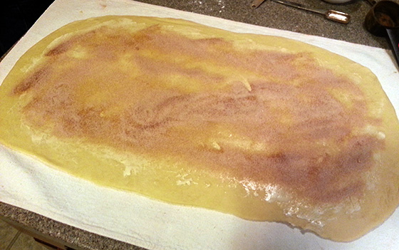 King Cake rolled out with butter, cinnamon, sugar